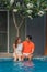 Asian couple have goodtime together on summer vacation at pool side in hotel and resort