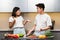 Asian Couple Having Conflict While Cooking In Kitchen At Home