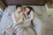 Asian couple in love, sleeping together on bed at night