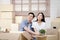 Asian couple moving into a new home Help unpack the brown paper box to decorate the house.