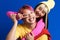 Asian couple with multicolored hair hugging while showing piece sign