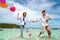 Asian couple run and happy on Pattaya beach with balloon on hand