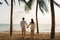 Asian couple is running and holding hands on a beachfront beach sea with coconut trees while on vacation in the summer in Thailand