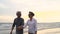 Asian couple senior elder retire resting relax holding hand walking at sunset beach honeymoon family together