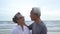 Asian couple senior elder retire resting relax kissing and hugging sunset beach
