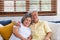 Asian couple senior embracing and sitting comfortably on sofa and  watching tv in living room at home