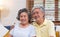 Asian couple senior embracing and sitting comfortably on sofa and watching tv in living room at home.