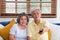 Asian couple senior sitting on sofa and use remote control to change channel and watching tv in living room at home