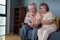 Asian couple of seniors smiling and looking at the same tablet on the sofa at home