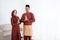 Asian couple smile with gestures of apologize when wish Happy Ramadan Kareem