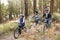 Asian couple and son cycling in a forest, side view