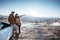 asian couple standing and enjoying the view of beautiful cappadocia in snow