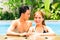 Asian couple swimming in resort pool