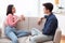 Asian Couple Talking Enjoying Conversation Sitting On Couch At Home