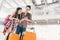 Asian couple travelers using smartphone checking flight or online check-in at airport, with passport and luggage