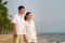 Asian couple is walking and hugging on a beachfront beach sea with coconut trees while on vacation in the summer in Thailand