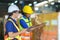 Asian couple warehouse workers checking shipment status on digital tablet computer prepare for delivery to customer. Employees