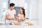 Asian couples cooking and baking cake together in kitchen room. Man and woman looking to each other at home. Love and happiness