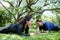 Asian couples exercising and planking workout together on grass field in the garden. Social distancing and new normal life