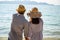 Asian couples stand hand in hand at the sea