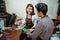 an asian craftsman showing a pad to a craftswoman