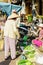 Asian customers and trader selling fresh bitter melon and zucchini