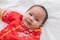 Asian cute baby boy Chinese Cheongsam costume toddler lie down on bed at home smiling laughing good humored  infant Chinese