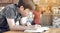 Asian cute boy read books while waiting for their mothers to buy drinks in the cafe