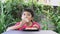 Asian cute boy in red shirt happily sitting eating pizza.