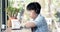 Asian cute boy using cell phone and sipping milk in the cup and smiles.