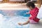 Asian cute girl kid enjoying kick water in the pool.