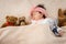 Asian cute little girl, Lying in a light brown bed, wearing headband on his head, Beside left and right, full of many teddy bears