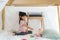 Asian cute little girl play cooking and feeding food to her doll while sitting in a blanket fort in living room at home for