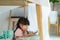 Asian cute little girl watching cartoon in smartphone while lying in a blanket fort in living room at home for perfect hideout