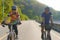 Asian cyclist couple riding together for exercise around the lake in the morning with beautiful mountain view in the background