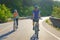 Asian cyclist couple riding together for exercise around the lake in the morning with beautiful mountain view in the background