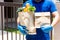 Asian deliver man holding bag of food, fruit, vegetable give to costumer in front of the house. Postman giving.stay at home concep