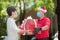 Asian delivery man wearing face mask and gloves in red uniform and Christmas hat delivering present and gift boxes during COVID-19