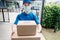 Asian Delivery man wearing mask send a package carton on front receiver shipping deliver social distancing