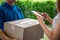 Asian deliveryman delivering package parcel food to woman, she use smartphone scan bar-code