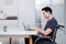 Asian disabled men Ride in a wheelchair Working on a laptop computer At the office in his home.