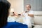 Asian Disabled senior elderly man sitting on sofa doing physiotherapist with support from therapist nurse. Older handicapped man u