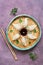 Asian dumplings with soy sauce served on a plate on a rustic purple background. Flat lay.