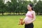 Asian Eastern Chinese happy pregnant woman in yoga dress hands hold her belly expecting baby to born gift box beside