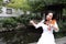 Asian Eastern Chinese young artist player woman carry play violin perform music park garden nature sit on bench outdoor nature