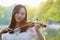 Asian Eastern Chinese young artist woman play violin by river in a park garden outdoor nature sunset sunrise day musical close-up