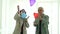 Asian elder couple winer coat have fun together play with heart balloons floating