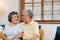 Asian elderly couple holding their hands while taking together in living room, couple feeling happy share and support each other