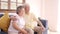 Asian elderly couple watching television in living room at home.