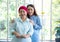 Asian elderly mother wearing red headscarf recover from cancer standing holding walking stick and having her daughter by her side